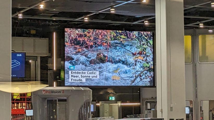 digitaler Screen am Flughafen Düsseldorf zeigt ein touristisches Motiv aus der spanischen Region Cadiz.