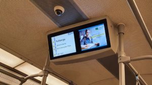 In einem Shuttle Bus wirbt die BBW-Hochschule auf einem Fahrgastfernsehen. Auf der linken Seite ist die Fahrtroute zusehen und auf der rechten wird der Werbespot ausgestrahlt. Sie werben für Anmeldung für das diesjährige Wintersemester.