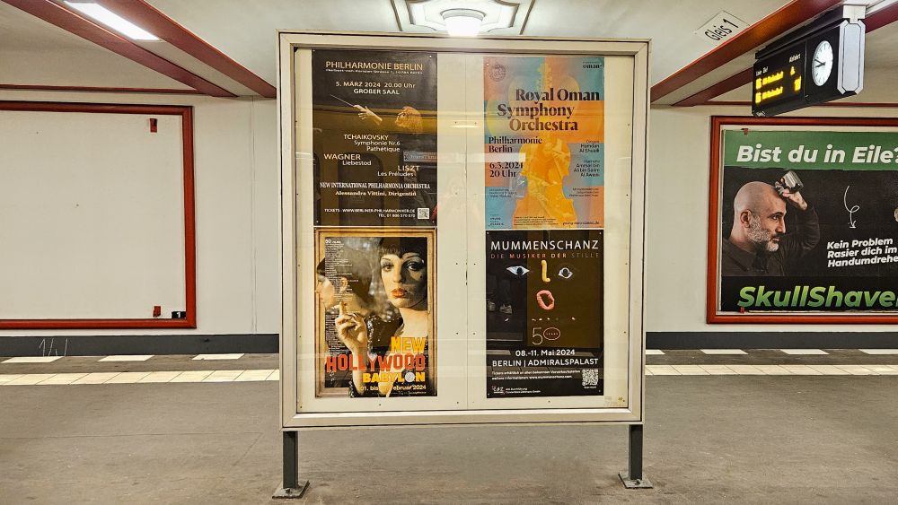 In der Plakatvitrine auf einem U-Bahnhof in Berlin sieht man 4 Plakate, die verschiedene Konzerte und Events bewerben.