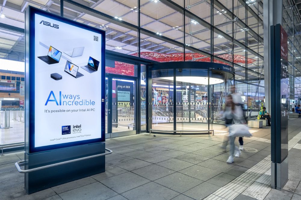 Am Eingang des Ankunftsbereiches vom Flughafen BER sieht man ein Digitalen City Light Poster mit der Werbung von ASUS. At the entrance of the arrivals area of BER airport you can see a Digital City Light Poster advertising for ASUS.
