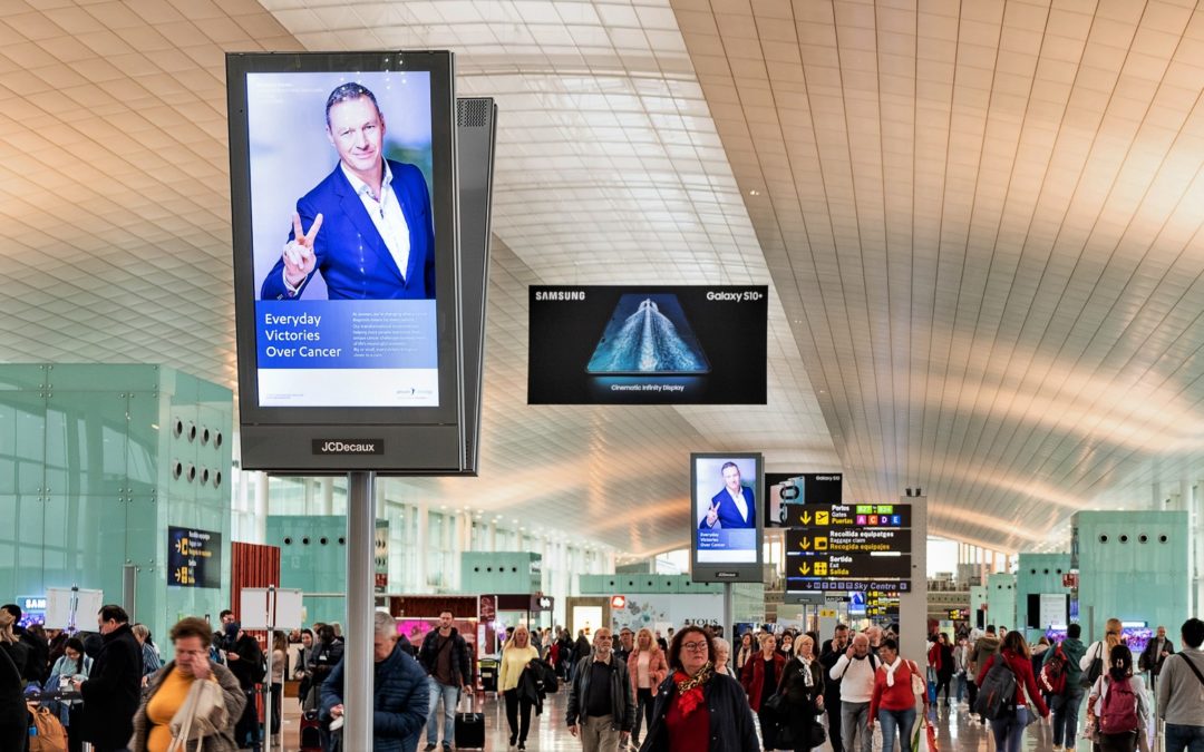 Digitale Werbeträger am Flughafen in Barcelona mit einer Kampagne "gemeinsam gegen Krebs"