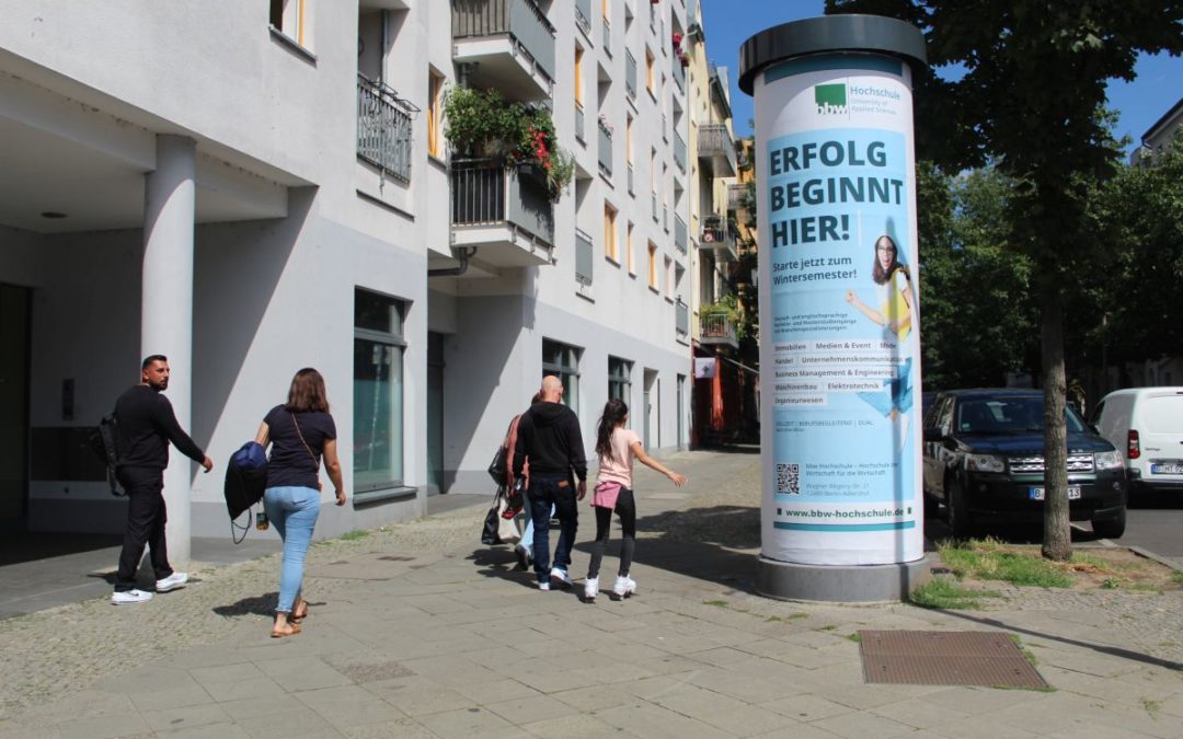 Säulenwerbung in Berlin Köpenick an einer hochfrequentierten Kreuzung. Auf dem 8/1 Plakat die bbw Hochschule mit dem Motiv „Wintersemester“
