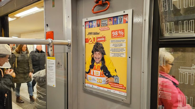 wtm Innenwerbung Im Mittelpunkt ist ein Seitenflächenplakat In der Berliner U-Bahn. In der Plakatwerbung sieht man das Prime Time Theater.